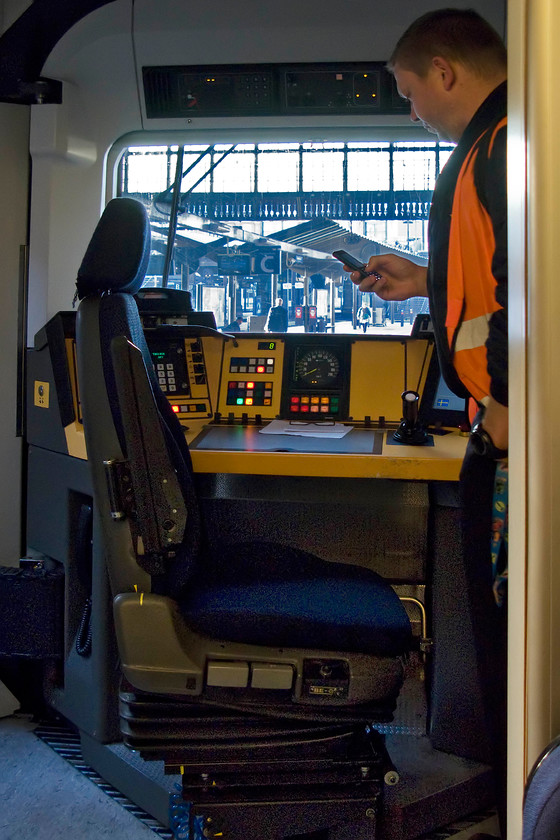 Driver & cab, 4411, 07.32 Copenhagen Central-Gteborg Central, Copenhagen Central station 
 The driver does what all drivers do before they take their train away, check their mobile 'phone! He has just boarded ET set 4411 at Copenhagen Central station ready to work the 07.32 to Gteborg (En. Gothenburg). He will soon close the interconnecting door and get the train away that we travelled on as far as the airport that was the next station. 
 Keywords: Driver cab 4411 07.32 Copenhagen Central-Gteborg Central Copenhagen Central station Class ET