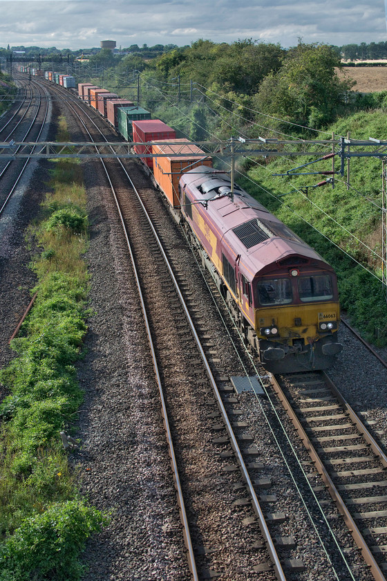 66063, 13.15 Trafford Park-London Gateway (4L56, 3L), Victoria bridge 
 Since it arrived at Newport docks on board the MV Fairmast during February 1999 66063 has only ever looked as it does here some twenty-one years later! It is one of those that still wears the full 'three beasties' EWS livery and branding despite that company being sold to Deutsche Bahn (DB) back in November 2007! The Class 66 is seen passing Victoria bridge between Roade and Ashton leading the 13.15 Trafford Park to London Gateway Freightliner. 
 Keywords: 66063 13.15 Trafford Park-London Gateway 4L56 Victoria bridge EWS DB Freightliner