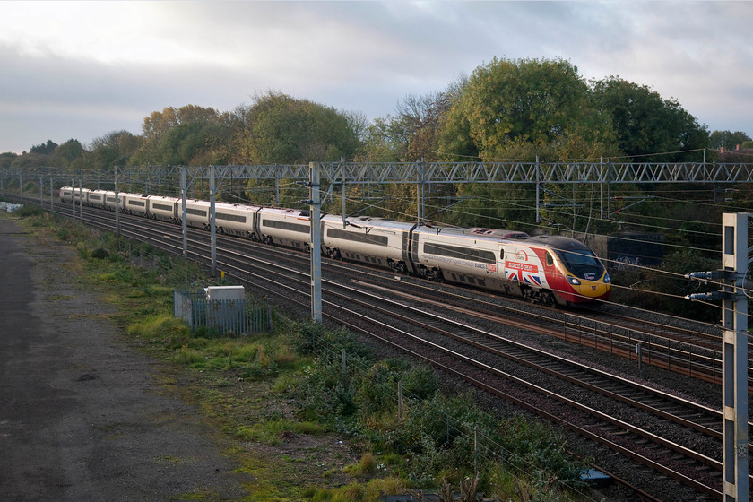 390151, VT 07.20 London Euston-Manchester Piccadilly (1H09, 3L), site of Roade station 
 As well as being named 'Virgin Ambassador' 390151 is also branded with the large 'Business is Great' vinyls on coaches A and K. The Pendolino is seen passing the site of the old Roade station with the 07.20 Euston to Manchester Piccadilly. The autumn colours are beginning to show through on the trees, but once again it is a bit of a dull morning. 
 Keywords: 39015 07.20 London Euston-Manchester Piccadilly 1H09 site of Roade station