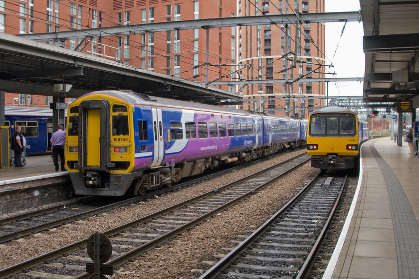 144022, NT 12.29 Leeds-York (2C30) & 158755, NT 12.18 Leeds-Manchester Victoria (2M10), Leeds station 
 Our fifth and final train of the day is Pacer 144022 that will take us from here at Leeds to Knaresborough anticlockwise via Harrogate. Next to the 12.29 Leeds to York is the 12.18 to manchester Victoria made up of 158755. According to the time code on the camera and the guard's position at the rear cab of the unit I believe that the doors were being closed as it readied for its departure. 
 Keywords: 144022 12.29 Leeds-York 2C30 158755 12.18 Leeds-Manchester Victoria 2M10 Leeds station Pacer Northern Rail