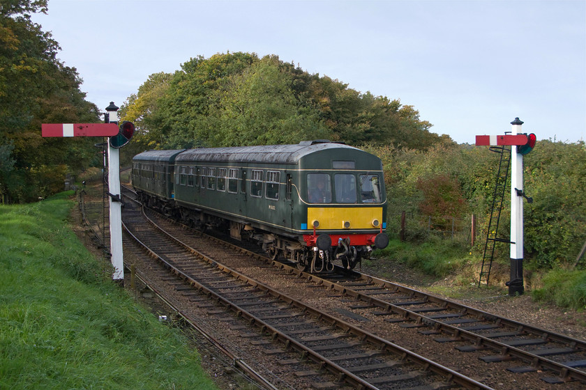 M56352 & M51192, 10.30 Holt-Sheringham, Weybourne 
 The 10.30 Holt to Sheringham service arrives at Weybourne not particularly well framed it has to be said by the two ex. GE somersault signals! The train is worked by a Class 101 DMU combination formed of M56352 (leading) and M51192. The leading car still wears its BR (non-operational) high-intensity centre light and small yellow warning panel and is in green so represents three different eras throughout its operational life. Despite it being largely in the shade I love the lighting in this photograph that could only have been taken in the autumn. 
 Keywords: M56352 M51192 10.30 Holt-Sheringham Weybourne Class 101 DMU