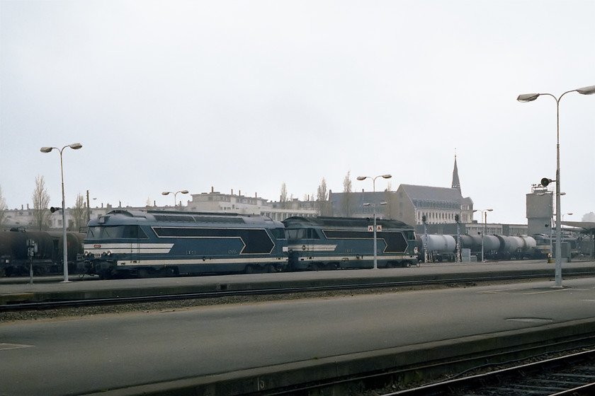 67035 & 67032 light engines & 67441, tanker train, Nantes station 
 A trio of class BB 67s at Nantes station. In the foreground are 67035 and 67032 running through the station light engine from the east. Behind them, a member of the 674XX sub-class 67441 wait with an east bound tanker train. This was probably making its way to the Total Donges oil refinery a short distance just down the river near to St. Nazaire. 
 Keywords: 67035 67032 67441 tanker train Nantes station