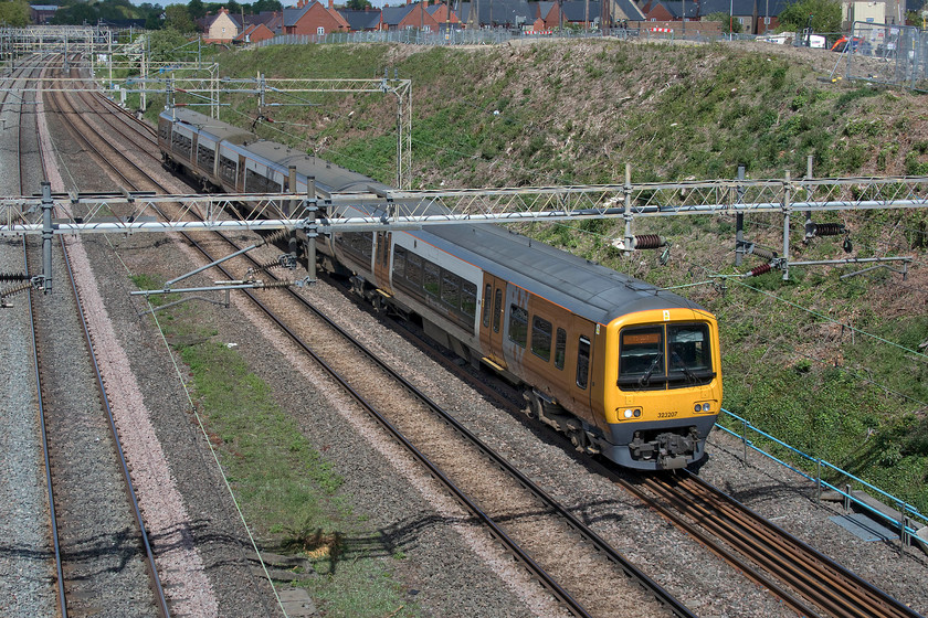 323207, 11.03 Soho LMD-Wolverton Centre sidings (5Z23, 92E), Ashton Road bridge 
 Running nearly two hours early, 323207 runs under bridge 207 just south of Roade as the 11.03 Soho depot to Wolverton Works. The Class 323 will undergo attention at the works with the driver then taking another unit back to the Midlands later in the afternoon. Unfortunately, despite looking out for it and ready to get back out to photograph it, the unit popped out on to the north release line and was off very quickly and I heard it passing my home at Roade as I was hanging the washing on the line! 
 Keywords: 323207 11.03 Soho LMD-Wolverton Centre sidings 5Z23 Ashton Road bridge