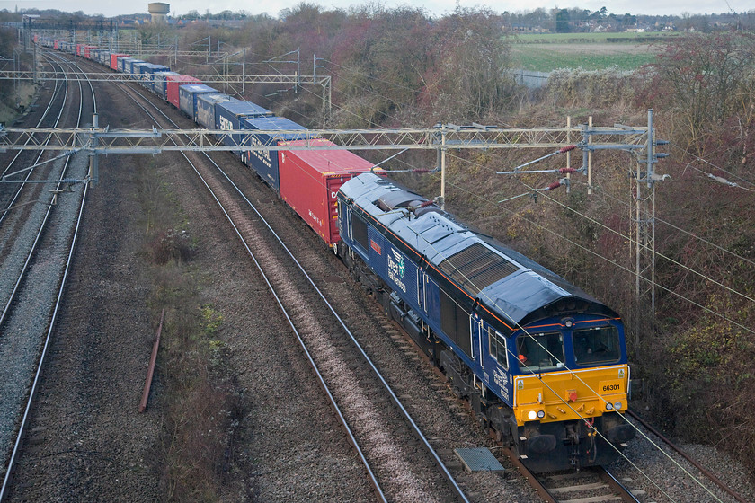 66301, 13.51 DIRFT-Ripple Lane FLT (4L48), Victoria bridge 
 DRS 66301 'Kingmoor TMD' leads the 13.51 Daventry Railfreight Terminal to Ripple Lane terminal past Victoria bridge just south of Roade. This Freightliner service would normally have gone to Purfleet but, according to RTT, 'This service was cancelled between Ripple Lane F.L.T. and Purfleet Deep Wtr Wf (Flt) due to a request by the customer (FL).' However, I have my doubts as to the accuracy of this as RTT has having a 'funny' on this afternoon with some services not being accurately recorded. 
 Keywords: 66301 13.51 DIRFT-Ripple Lane FLT 4L48 Victoria bridge