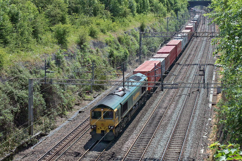 66542, 07.50 Felixstowe North-Lawley Street (4M94, 43E), Roade cutting 
 Another long and well loaded Freightliner indicating that, after a bit of a lull during the height of the pandemic, freight is getting through again. 66542 leads the 4M94 07.50 Felixstowe North to Lawley Street (Birmingham) through Roade cutting. After a heavy shower, the sun has just broken through finding a patch of clear sky. 
 Keywords: 66542 07.50 Felixstowe North-Lawley Street 4M94 Roade cutting Freightliner