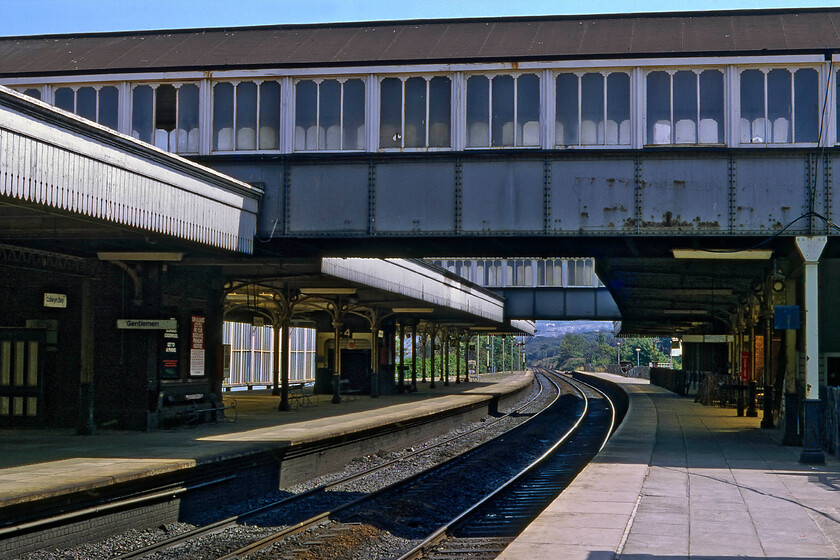 Colwyn Bay station 
 Looking east through Colwyn Bay station illustrates a traditional and attractive structure. It also reveals its unusual location on a sharp curve in the line necessitating a steep camber on the tracks that can just be seen in the foreground. The station was opened by the Chester and Holyhead Railway in October 1849 named Colwyn to become Colwyn Bay in 1876. In the early 1980s, soon after this photograph was taken, the life of the station was severely disrupted by the construction of the A55 'Expressway' that goes through a short tunnel directly below the station's entrance forecourt. 
 Keywords: Colwyn Bay station