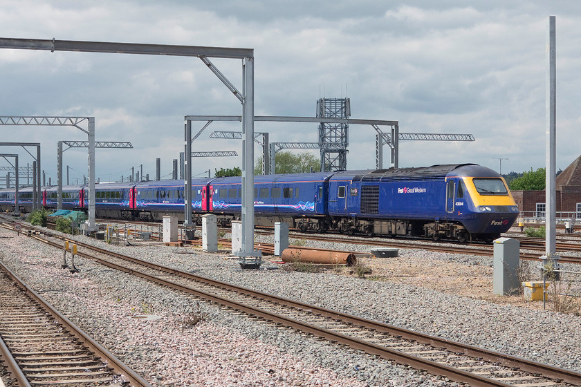 43004, GW 12.36 Cheltenham-London Paddington (1L58), Reading station 
 43004 'First for the Future/First ar gyfr y dyfodol' arrives at Reading with just a hint of sunshine illuminating its side. It is negotiating the plethora electrification masts that have been installed at the western end of the station leading the 1L58 12.36 Cheltenham to Paddington. 
 Keywords: 43004 12.36 Cheltenham-London Paddington 1L58 Reading station