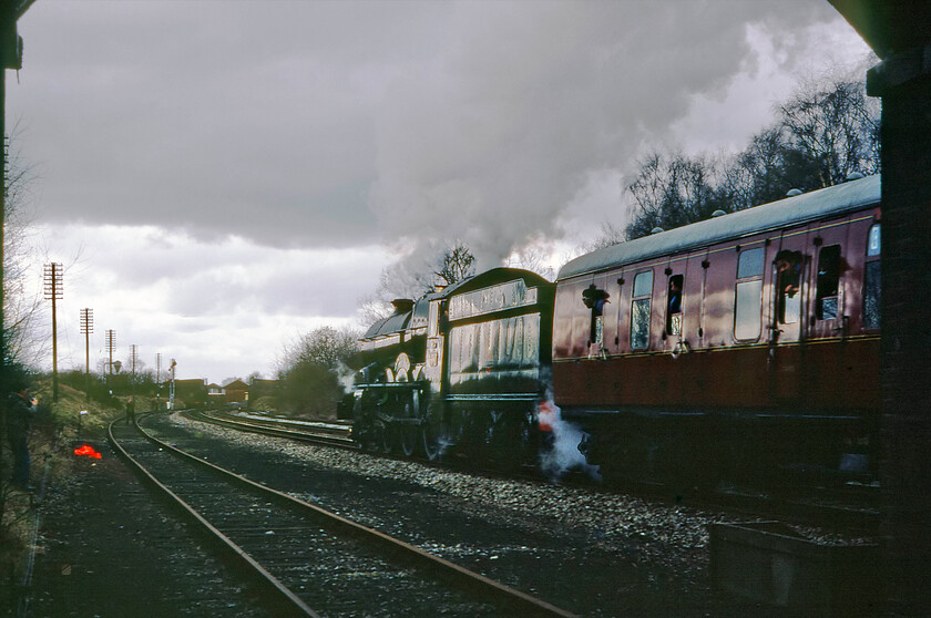 6000, outward leg of The Welsh Marches Express, 10.15 Crewe-Newport, Wooffereton, SO518688 
 I am not a particular fan of going-away photographs but when it is actually better than the approaching version it firmly makes the cut! 6000 'King George V' thunders past Woofferton leading the outward leg of The Welsh Marches Express that it had led from Shrewsbury. On arrival at Herford, some nineteen miles south of this spot, the King would come off in favour of former GWR 4-6-0 'Hagley Hall'. As well as the train, this image is full of interest. In the very background Woofferton's superb London and North Western & Great Western Joint type 1 1875 signal box. Also, note the enthusiasts on the track, as I was, and an abandoned hi-viz jacket next to a microphone on an adapted tripod no doubt picking up the sounds and committing it to cassette tape. 
 Keywords: 6000 The Welsh Marches Express 10.15 Crewe-Newport Wooffereton SO518688 King George V