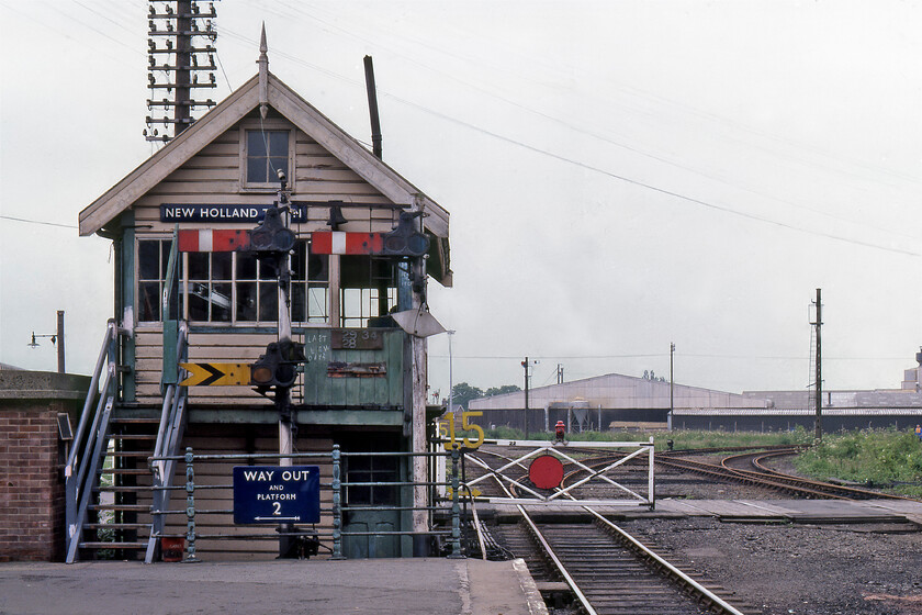 New Holland Town signal box (RSCo, 188X) 
 From the platform end of the doomed New Holland Town station, the signal box of the same name is seen. Both would close within a week with the opening of the Humber bridge to take place on 24.06.81. Indeed, the signalman has chalked on the green board just in front of the box's door 'Last few days'. The line curving off to the right leads to Barton-on-Humber controlled by the submissive arm number 34. The BR (E) flanged enamel guiding passengers away from the station is a great example of much of the infrastructure around this station and the pier that led out into the Humber estuary behind me. 
 Keywords: Railway Signalling Company RSCo New Holland Town signal box