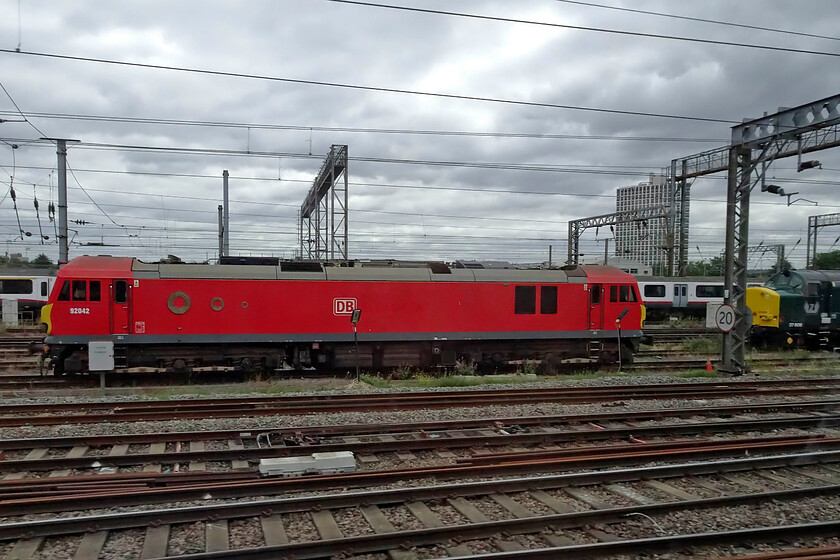 92042 & 37608, stabled, Wembley Yard 
 A broadside view of 92042 stabled in Wembley Yard as we pass at line speed aboard the 09.06 Birmingham to Euston service. Just appearing in-shot to the right is 37608 'Andromeda' which I di not, unfortunately, manage a better photograph of. 
 Keywords: 92042 37608 stabled Wembley Yard Andromeda