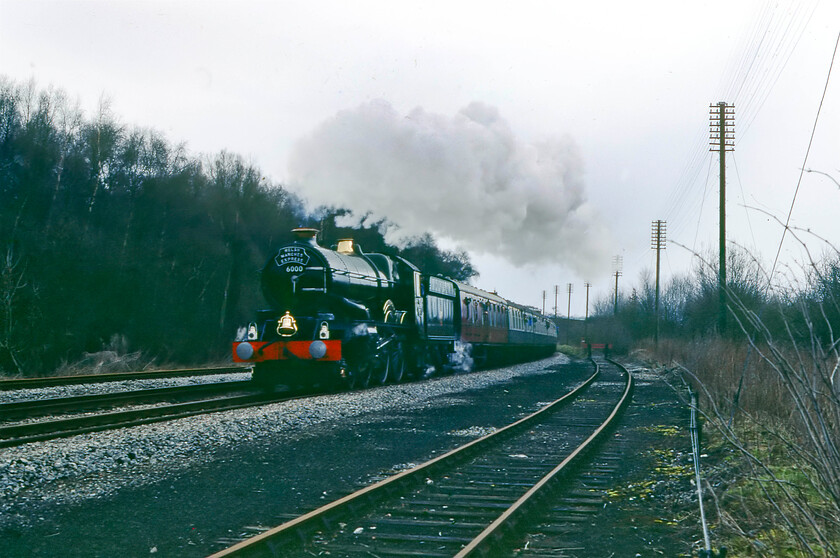 6000, outward leg of The Welsh Marches Express, 10.15 Crewe-Newport, Wooffereton, SO518688 
 On such a dull day the Kodachrome 64 slide film was really struggling when a fast shutter speed was required as here just north of Woofferton between Leominster and Ludlow. This photograph was practically a mass of darkness with a burnt-out sky but I have managed to resurrect it to some degree in Photoshop. It shows 4-6-0 King Class 6000 'King George V' leading the southbound Welsh Marches Express from Crewe to Newport that it led from Shrewsbury to Hereford. Ironically, the going-away photograph was marginally better being framed by the road bridge under which I was standing. 
 Keywords: 6000 The Welsh Marches Express 10.15 Crewe-Newport Wooffereton, SO518688 King George V