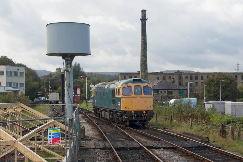 33035, running round, Rawtenstall station 
 33035 is seen running round at Rawtenstall ready to work the return train to Heywood. It will run down towards the level crossing and return towards me under the water tower. This manoeuvre is controlled by the signalman in Rawtenstall West signal box that can be seen in the background. Dominating the scene is the late nineteenth century Hardman's Cotton Mill. It is a grade two listed structure and currently in use split into small industrial and office units. 
 Keywords: 33035 running round Rawtenstall station