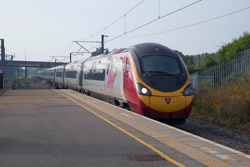 390131, VT 07.20 London Euston-Manchester Piccadilly (1H09, 3L), Milton Keynes Central station 
 Pendolino 390131 'City of Liverpool' arrives into Milton Keynes station working the 07.20 London Euston to Manchester Piccadilly. The early morning was dawning in a positive manner with weak sunshine that was more than likely going to burn off some light high cloud. 
 Keywords: 390131 1H09 Milton Keynes Central station