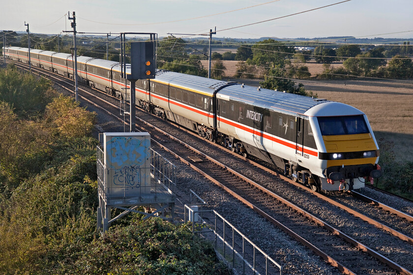 82139 & 90002, 16.21 Manchester Piccadilly-London Euston (1Z96, 4L), Milton crossing 
 A popular photographic local location to me is the footbridge at one of the two former foot crossings between Blisworth and Milton Malsor. From the mid-afternoon onwards on a sunny day, it offers commanding and well-lit views of both north and southbound services often attracting a number of enthusiasts when something out of the ordinary is about; this particular evening was no exception! DVT 82139 leads the 1Z96 16.21 Manchester Piccadilly to Euston LSL (Locomotive Services Limited) 'charter' but that was operating, to all intents and purposes, as a service train with a first-class walk on flat fare. 
 Keywords: 82139 90002, 16.21 Manchester Piccadilly-London Euston 1Z96 Milton crossing InterCity DVT