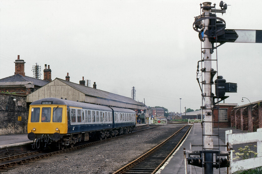 Class 114 DMU, 14.00 Cleethorpes-New Holland Pier, New Holland Town station 
 The 14.00 Cleethorpes to New Holland Pier service pauses at New Holland Town station. The track to the right in this view controlled by the signal that is half in shot was infrequently used by this time hence the rusty railhead. This photograph was taken less than a week before the closure of the station and the line running along the pier to the ferry head with the opening of the Humber bridge a few miles to the west. 
 Keywords: Class 114 DMU 14.00 Cleethorpes-New Holland Pier New Holland Town station first-generation DMU