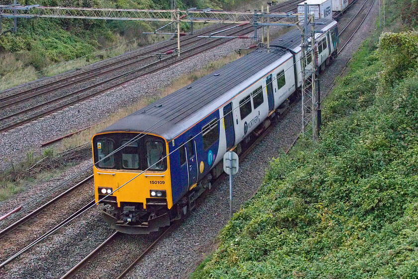 150109, 10.50 Newton Heath TMD-Wolverton Centre Sidings (5H70, 3E), Victoria bridge 
 Running on time, the 5H70 10.50 Newton Heath to Wolverton Centre Sidings 150109 empty stock move is within a few miles of its destination as it passes Victoria bridge just south of Roade. Having spoken with an employee of Gemini Rail Group at Wolverton I wonder if this unit, going for a refurbishment (probably its last before withdrawal), will have the rotten vestibule floor malaise that the other Class 150s he has worked on have had? 
 Keywords: 150109 10.50 Newton Heath TMD-Wolverton Centre Sidings 5H70 Victoria bridge Northern