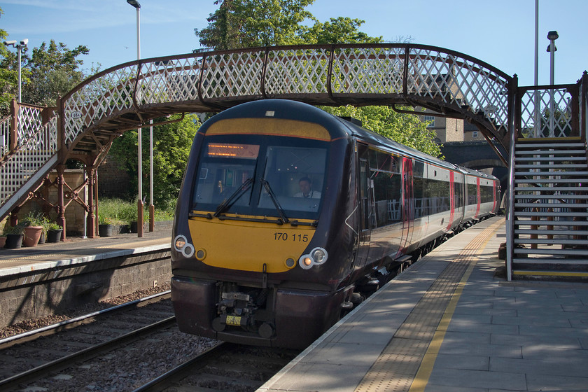 170115, XC 07.21 Stansted Airport-Birmingham New Street (1N45, 4L), Stamford station 
 It's good to see that Stamford station still retains its original wrought iron and timber footbridge with so many having been swept away to be replaced by ghastly modern and over-engineered structures. Under clear blue skies but, unfortunately, in the shade, Cross Country's 170115 arrives with the 07.21 Stansted Airport to Birmingham New Street service. This train was busy and it begs the question as to whether a two-car DMU is an appropriate formation for a service such as this? 
 Keywords: 170115 07.21 Stansted Airport-Birmingham New Street 1N45 Stamford station