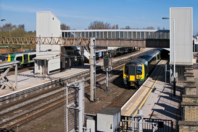 350261, LM 09.14 Birmingham New Street-London Euston & 350255, stabled, Northampton station from Westbridge Road (A428) 
 A scene taken from the Westbridge Road bridge looking northwards through Northampton station shows the footbridge and platforms. In the plans that I have seen, the footbridge and lifts are to be replaced and relocated much nearer to the camera. To the right 350261 waits at platform one working London Midland's 09.14 Birmingham to Euston service whilst to the left 350255 is seen stabled in the Riverside sidings. 
 Keywords: 350261 09.14 Birmingham New Street-London Euston 350255 Northampton station from Westbridge Road A428 London Midland Desiro