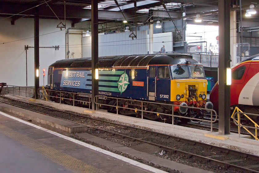 57302, stabled Thunderbird, & 390002, London Euston station 
 On arrival at Euston DRS operated (For Virgin Trains) Thunderbird 57302 'Chad Varah' is seen stabled. Just putting in an appearance to its right is 390002 that will be heading back north with a Virgin service sooner than later. 
 Keywords: 57302, Thunderbird 390002 London Euston station Chad Varah DRS Thunderbird Virgin Pendolino