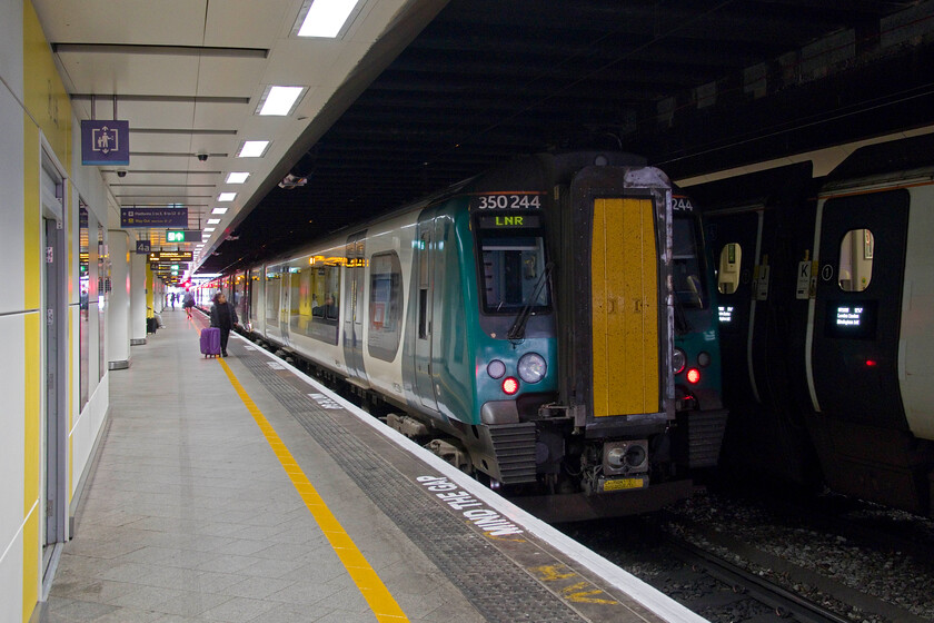 350244, LN 12.36 Birmingham New Street-London Euston (1Y40, 2L), Birmingham New Street station 
 Our train home from Birmingham to Northampton stands in the gloom at New Street worked by 350244. After its protracted and very expensive redevelopment a few years ago I might have hoped that the ambience on the platforms would have been improved but, alas it remains a dark and oppressive place that is not roomy enough to handle all of the passengers using it at certain times. 
 Keywords: 350244 12.36 Birmingham New Street-London Euston 1Y40 Birmingham New Street station London Northwestern desiro