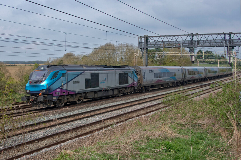 68032, 09.35 Longsight-Wolverton Works (5Q70, 23E), between Roade & Ashton 
 68032 'Destroyer' leads the 09.35 Longsight to Wolverton Works stock move along the up fast line between Roade and Ashton in Northamptonshire close to its destination. This working nearly caught me out as I left home with it arriving at Rugby about twenty minutes early assuming that it would be held as is usually the case. However, on checking RTT during my walk from home it had passed straight through Rugby and was already south of Kilsby tunnel so I had to get a move on! On a sunny day, this position would be tricky with this side of the train in deep shadow but with it being so overcast this spot had to suffice with me running short of time! 
 Keywords: 68032 09.35 Longsight-Wolverton Works 5Q70 between Roade & Ashton Destroyer