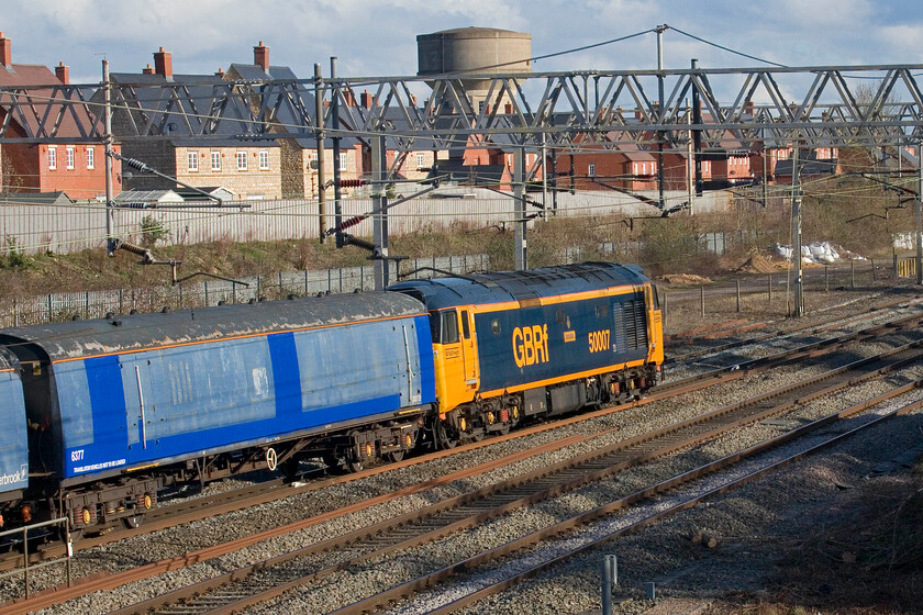 50007, 14.49 Willesden TMD-Leicester LIP (5F69, 30E), site of Roade station 
 50007 'Hercules' brings up the rear of the 5F69 14.49 Willesden TMD to Leicester translator train move passes the site of Roade station. This livery really suits the veteran locomotives and is vaguely reminiscent of their 'large logo' paint scheme worn following their final overhaul by BR. The translator vehicle seen here now running as 6377 is former EMU coach 1042. 
 Keywords: 50007 14.49 Willesden TMD-Leicester LIP 5F69 site of Roade station GBRf Hoover Hercules