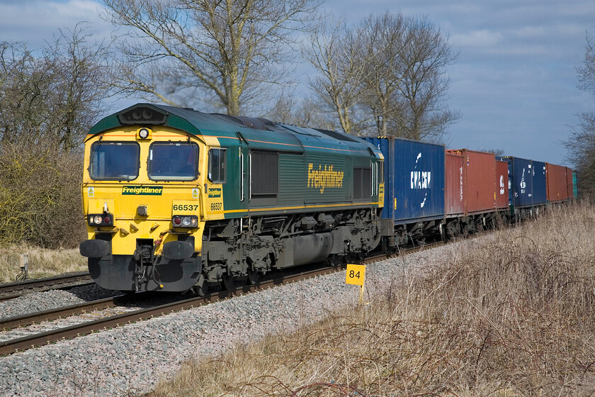 66537, 05.27 Leeds FLT-Southampton MCT (4O54), King's Sutton SP486377 
 66537 charges through the Northamptonshire countryside leading the 4O54 05.27 Leeds Freightliner terminal to Southampton Freightliner service. Notice that this member of the class appears to be suffering from the malaise that afflicts most of the class, namely corrosion staining emanating from around the windscreen apertures, however, in this example's case, the staining is not too extensive yet. 
 Keywords: 66537 05.27 Leeds FLT-Southampton MCT 4O54 King's Sutton SP486377 Freightliner