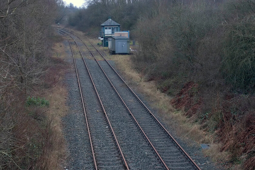 Looking south-east, Moira West (Junction), Spring Cottage Road bridge 
 Looking southeast from the Spring Cottage overbridge towards the once-busy Moira Junction reveals that the West Junction signal box still stands. However, everything in this scene is mothballed and non-operational since the withdrawal of freight along this route with all remaining stone traffic from the quarries near Coalville heading east to connect with the MML. Hidden in the undergrowth to the left is the long siding that led off up the steeply graded section to Radon Colliery. Martin Loader (aka The Hondawanderer) has a number of photographs taken in happier times, for example, see..... http://www.hondawanderer.com/56025_Moira_West_Junction_1989.htm 
 Keywords: Looking south-east, Moira West (Junction), Spring Cottage Road bridge .jpg