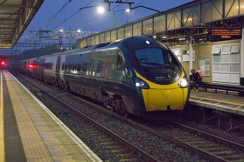 390049, VT 05.05 Manchester Piccadilly-London Euston (1A04, 11L), Motlton Keynes Central station 
 The first up service to London of the day from Manchester arrives at Milton Keynes station in the half-light of a grey and damp February morning. 390049 is working the 1A04 05.05 Piccadilly to Euston service. Technically, this is a tricky photograph with a fair amount of digital noise that the excellent Photoshop plug-in software Neat Image has taken care of. 
 Keywords: 390049 05.05 Manchester Piccadilly-London Euston 1A04 Milton Keynes station Avanti West Coast AWC Pendolino