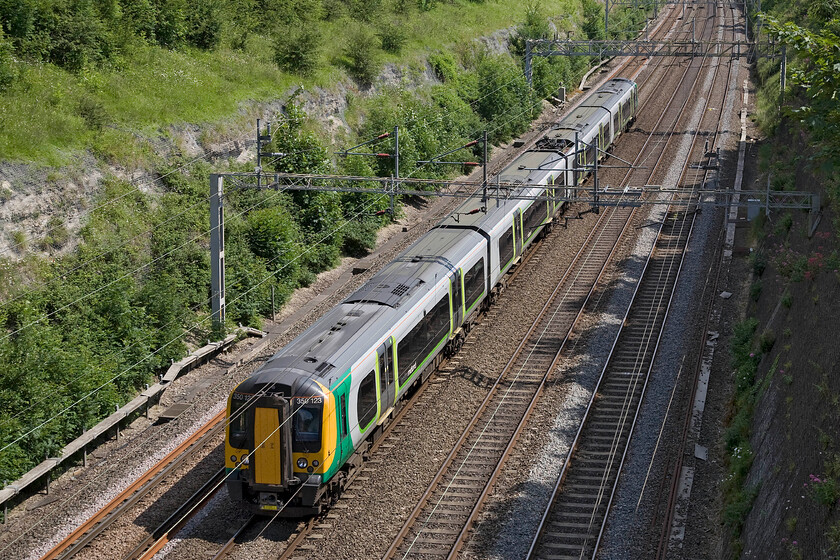 350123, LM 14.13 London Euston-Birmingham New Street (1Y45), Roade cutting 
 350123 works the 14.13 Euston to Birmingham New Street Saturday afternoon service through Roade cutting. Not content with sixty-seven sets (divided into two subsets, 3501XX and 3502XX) London Midland are about to introduce a further ten of these highly successful units to be designated 3503XX. This is, of course, in addition to TransPennine Express currently introducing ten of their own designated 3504XX for use on their Anglo Scottish services, see..... https://www.ontheupfast.com/p/21936chg/29872327204/x92044-350406-350407-04-20-dollands 
 Keywords: 350123 14.13 London Euston-Birmingham New Street 1Y45 Roade cutting London Midland Desiro