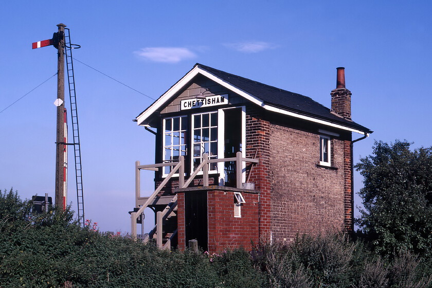 Chettisham signal box (GE, 1883) 
 As we approached Ely earlier from the west I am not too sure why we did not stop at Chettisham to photograph the signal box but we made up for this by calling in later on our way northwards towards Kings Lyn. Chettisham was the first box on the Ely to March line after Ely North Junction and was a relatively short block section from there. It controlled the level crossing and access to a former Government storage depot that had been converted to a grain store that allegedly sent its contents to various Scottish distilleries. The crossing is now automated and the road quiet but back in 1981 before the opening of the Ely/Littleport A10 bypass the signalman was kept busy in the box with the road being heavily used. Notice the slotted concrete signal post that was probably of LNER origin. The box is a standard Great Eastern design dating from 1883. 
 Keywords: Chettisham signal box GE Great Eastern