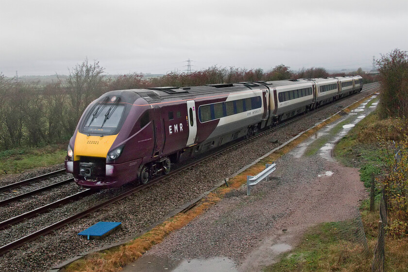 222021, EM 08.12 Nottingham-London St. Pancras (1B22, 2L), Braybrooke SP769849 
 With snow gathering on the front of 222021, it passes a very cold Braybrooke just south of Market Harborough. The EMR Meridian is working the 1B22 08.12 Nottingham to St. Pancras train that despite the inclement weather arrived on time in London. With less than twelve months left in service on this route now, these units will be replaced by Hitachi built Class 810 Aurora bi-mode trains even if the electrification extension to Market Harborough is not complete. This electrification will mean that the masts will dominate the scene at this relatively remote spot in north Northamptonshire with the county boundary with Leicestershire just over a mile distant from this spot. 
 Keywords: 222021 08.12 Nottingham-London St. Pancras 1B22 Braybrooke SP769849 East Midlands Railway EMR Meridian