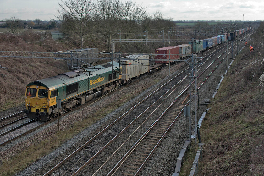 66512, 07.50 Felixstowe North-Lawley Street (4M94, 19E), Victoria bridge 
 With a team undertaking further embankment clearance at Ashton just south of Roade 66512 heads south leading the 4M94 07.50 Felixstowe to Lawley Street Freightliner service. Whilst recent work in Roade necessitated the closure of the fast lines over the Christmas and New Year period at this location trains were still passing at line speed with the lookout being kept busy. 
 Keywords: 66512 07.50 Felixstowe North-Lawley Street 4M94 Victoria bridge Freightliner