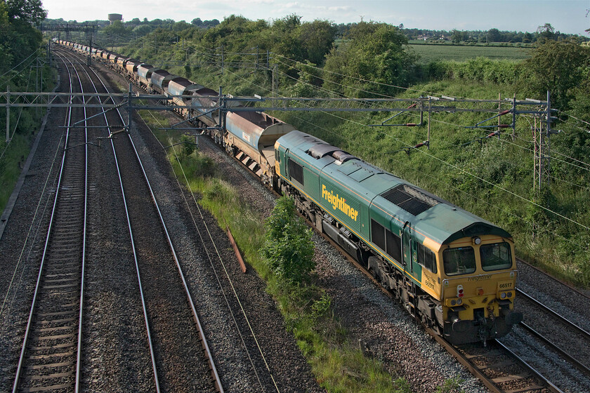 66517 & 66508, 17.56 Bletchley flyover-Bescot (6Y55, 18L), Victoria bridge 
 66517 brings up the rear of the 17.56 Bletchley Flyover to Bescot 6Y55 ballasting train with 66508 leading the train in the distance. This type of working is more usually associated with Sundays on the WCML so I was pleased that I had spotted it on RTT and that I made an effort to walk out after dinner to capture it. 
 Keywords: 66517 66508 17.56 Bletchley flyover-Bescot 6Y55 Victoria bridge 88 tonne Auto Discharge Bogie Ballast Wagon HQA (E)