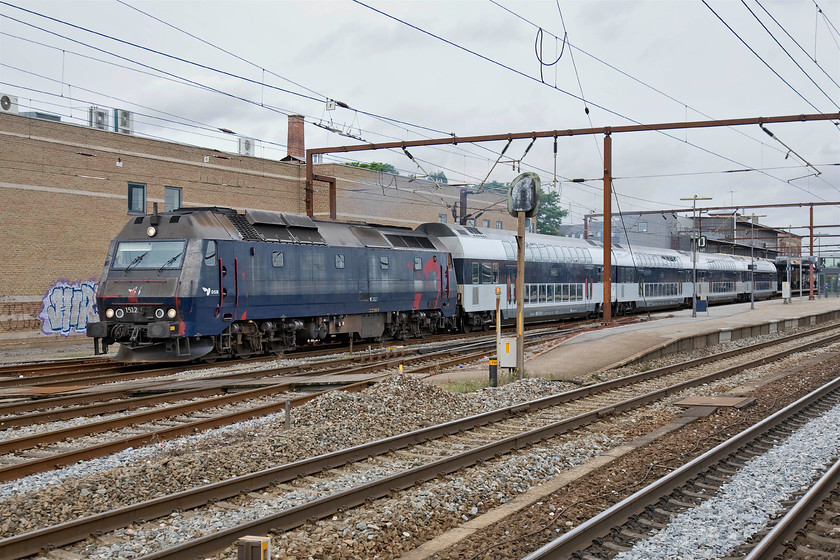 1512, 15.44 sterport-Kalundborg, Roskilde station 
 Class ME number 1512 makes a typically smokey departure from Roskilde station with the 14.44 sterport to Kalundborg service. These Henschel built locomotives date from 1981 but with the drive for electrification on DSB gathering pace, their time is limited now. This is no bad thing as they are probably deeply polluting and chronically inefficient when compared to what is available today and represent locomotives from a totally different design era. 
 Keywords: 1512 15.44 sterport-Kalundborg Roskilde station DSB Class ME