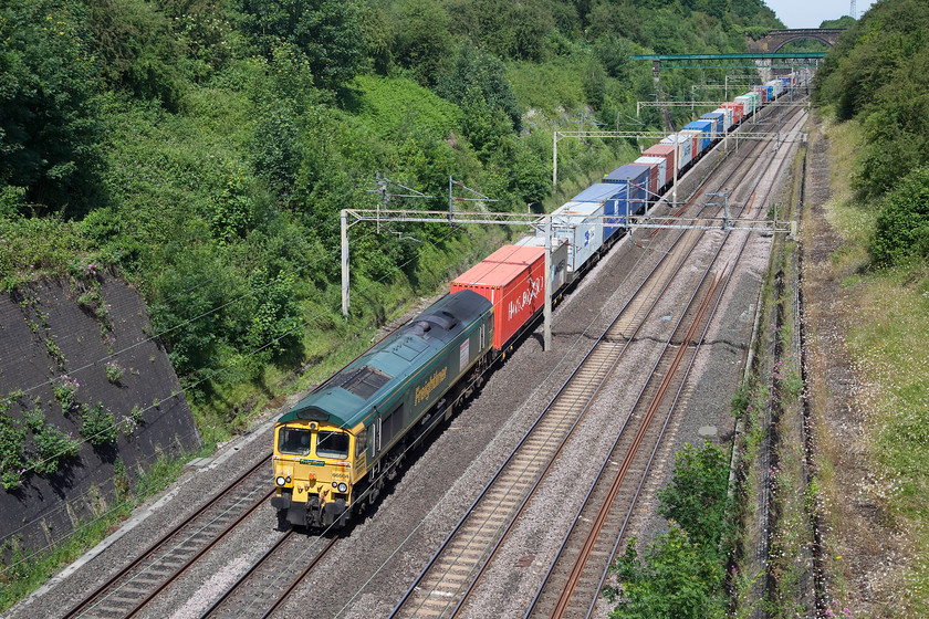 66564, 08.30 Lawley Street-Felixstowe North, Roade Cutting 
 Yet another freight passes through the impressive Roade Cutting on the up fast. This time, it's the 08.30 Lawley Street to Felixstowe North Freightliner. At its limited speed of 70mph it was holding up the passenger workings behind, there were many, all running on cuations by this time. The diversion was because the Northampton line was closed for an 'emergency incident'. 
 Keywords: 66564 08.30 Lawley Street-Felixstowe North Roade Cutting