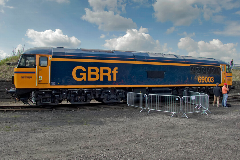 69003, on display, Barrow Hill 
 With its new nameplates covered up and to be named later in the day 56018 looks very smart in its GBRf livery standing in the sun at Barrow Hill. Formally numbered 56018 it is one of three Romanian-built members of the class selected to be rebuilt by Progress Rail at its Longport (Stoke-on-Trent) facility. With the rebuilding process retaining the origonal bogies from this angle, the Class 69 is instantly recognisable as a former Class 56 but from the front, there are some distinct differences. 
 Keywords: 69003 on display Barrow Hill 56018