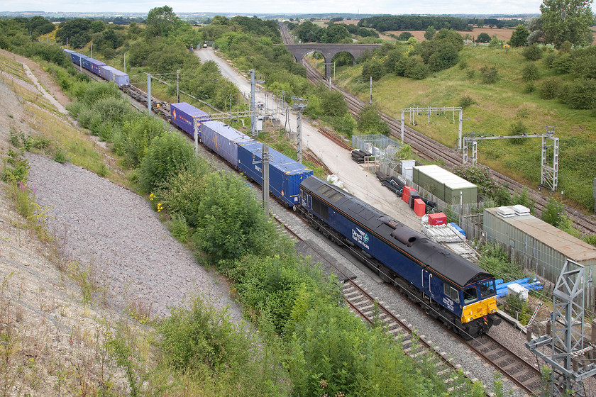 66426, 10.05 Daventry-Purfleet, via Weedon (4L98), Blisworth Road bridge 
 The unusual sight of a freight on the Weedon loop line. 66426 rushes past with the 10.05 Daventry (DIRFT) to Purfleet 4L98 Freightliner. It was routed this way due to engineering works on the Northampton area that is some distance down the line in the middle distance. The Freightliner first went north from DIRFT to Rugby. The locomotive then ran round the train and it headed south to this point. To get out of the way of the Virgin and London Midland workings backing up behind it, control will put it on the slow line as soon as possible. The next point south from here where they can do this is Hanslope Junction, about five miles away. 
 Keywords: 66426 10.05 Daventry-Purfleet via Weedon 4L98 Blisworth Road bridge