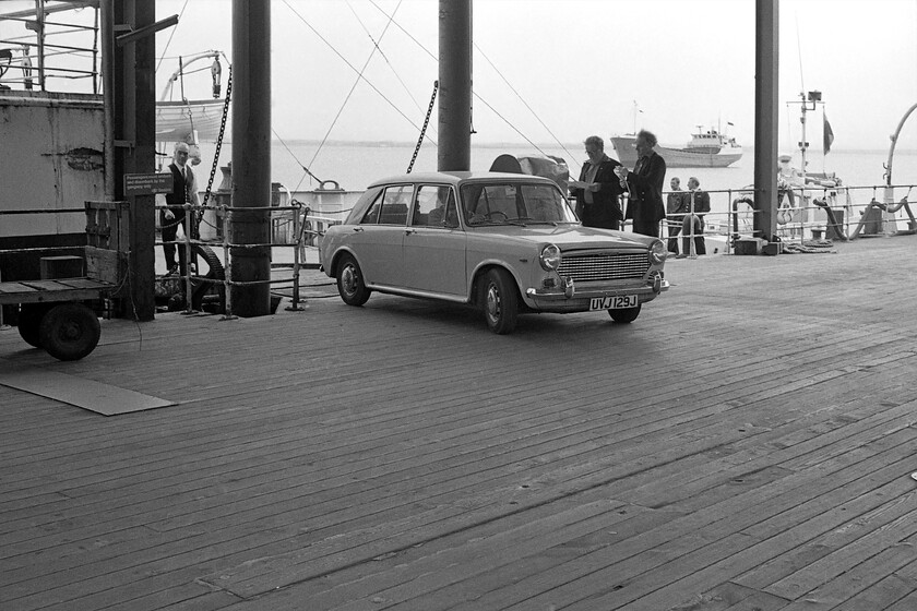 UVJ 129J, disembarking MV Farringford, Hull Corporation Pier 
 I think that Graham, driving the Austin 1100 UVJ 129J, was possibly the final vehicle to disembark from MV Farringford after its arrival at Hull Corporation Pier with the 16.50 service from New Holland. In this photograph, it appears that the pilot boat seen in an earlier image has come alongside seen low down close to the back of Farringford. An unidentified freighter is also seen moored slightly further out in the estuary. 
 Keywords: UVJ 129J disembarking MV Farringford Hull Corporation Pier Austin 1100 Sealink