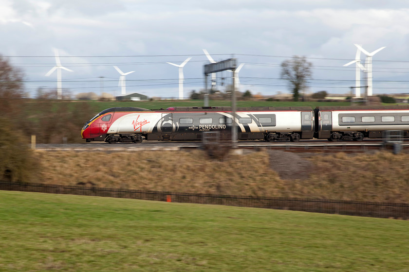 390104, 12.40 London Euston-Edinburgh (9S70, 1L), Roade Hill 
 With the M1 wind farm in the background 390104 'Alstom Pendolino' passes Roade Hill between Milton Keynes and Northampton with the 12.40 London Euston to Edinburgh. Pan shots can be effective in the right circumstances and give a different perspective to a 'normal' image of a working train. This particular image was taken using 1/125th sec. 
 Keywords: 390104 9S70 Roade Hill