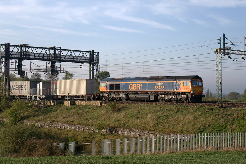 66735, 03.10 Felixstowe North-Trafford Park (4M21, 30E), between Roade & Ashton 
 In a repeat of yesterday, 66735 'Peterborough United' leads the 4M21 03.10 Felixstowe to Trafford Park Freightliner, see...... https://www.ontheupfast.com/p/21936chg/28991215604/x66735-03-10-felixstowe-north-trafford This time the location is between Roade and Ashton that is less than a mile from where yesterday's image was recorded. The driver of 66735 acknowledged me standing in the field taking this picture with a friendly blow of the horn. 
 Keywords: 66735 03.10 Felixstowe North-Trafford Park 4M21 between Roade & Ashton Peterborough United Freightliner