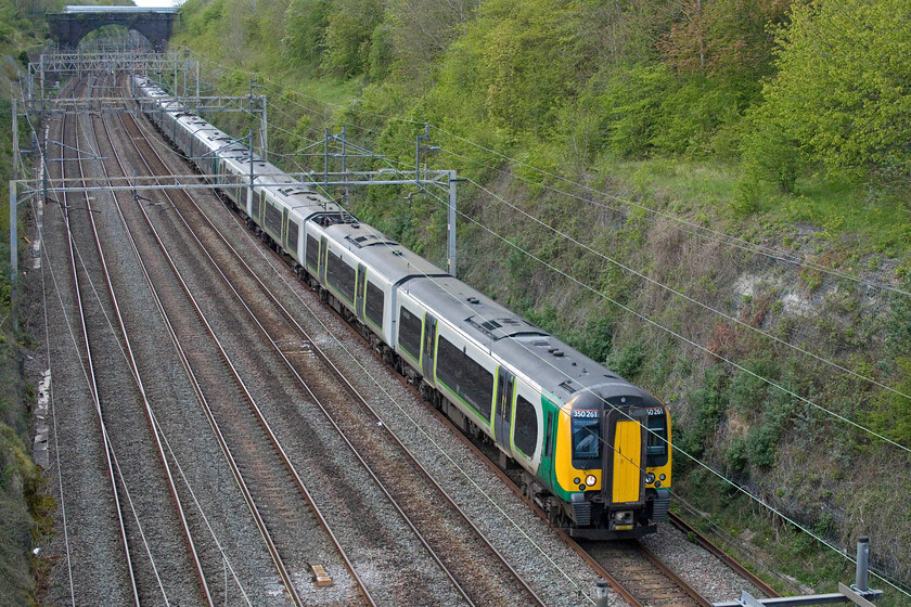 350261, 350107 & 350102, LN 15.33 Birmingham New Street-London Euston (1Y32, 16L), Hyde Road bridge 
 I am not sure as to why the 15.33 Birmingham New Street to Euston service has been strengthened to a three-set working composed of 350261, 350107 and 350102. However, being the day of the London Marathon it could be in an effort to add more seats on the return working later in the afternoon for the runners. However, this would mean advanced thinking and planning; not something the railways are known for being ale to manage these days! The train is seen passing through Roade from the village's Hyde Road bridge. 
 Keywords: 350261 350107 350102 15.33 Birmingham New Street-London Euston 1Y32 Hyde Road bridge London Northwestern Desiro