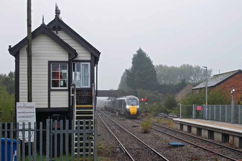 800005, GW 07.50 London Paddington-Great Malvern (1W15, RT), Moreton-in-Marsh station 
 High up in the Cotswolds Moreton-in-Marsh is enveloped in a damp September mist. 800005 'Aneurin Bevan NHS 1948-2023' approaches the station working the 1w15 07.50 Paddington to Great Malvern service. The train is about to pass the extended platform and the superb 1883 Great Western signal box. It appears that the box's windows have been replaced again. When the box was modernised in the noughties the mullion windows were replaced by huge single-pane UPVC units which were crassly out of character. However, as can be seen here the more recent units appear to be attempting to replicate the original timber frame windows even if only with plastic divider bars. 
 Keywords: 800005 07.50 London Paddington-Great Malvern 1W15 Moreton-in-Marsh station GWR IET Aneurin Bevan NHS 1948-2023