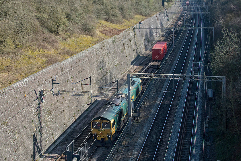 66558, 09.25 Southampton MCT-Garston FLT (4M58), Roade cutting 
 Another nearly empty Freightliner working passes through Roade cutting. 66558 leads the 09.25 Southampton to Garston train that had a handful of boxes on-board indicative of the lack of imports arriving on our shores due to the Covid-19 pandemic paralysing the normal international flows of freight. 
 Keywords: 66558 09.25 Southampton MCT-Garston FLT 4M58 Roade cutting Freightliner