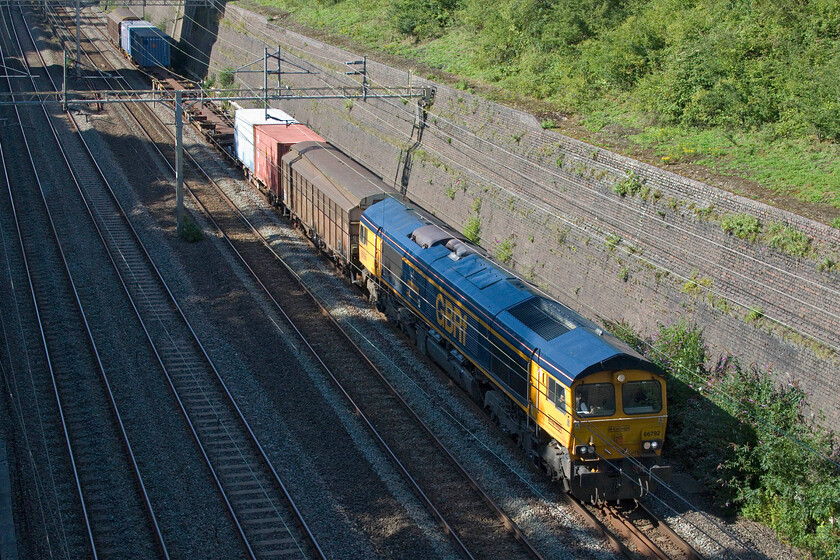 66792, 13.50 Kineton MoD-Marchwood MoD (3F01, 1L), Roade cutting 
 This working must be up there as one of the most unusual so far of the year on my 'home' section of track. Due to the further closure of the GW route around Oxford for enhancement work and preparations for the re-building of the station diversions were again in place for freight. There are irregular workings from the MoD depot at Kineton to Marchwood on the Solent that usually go via Oxford, Didcot and Reading which are handled by GBRf. The lengthy diversions find the 13.50 ex Kineton running as 3F01 passing through Roade cutting led by 66792 'Collaboration'. Note the interesting symmetrical formation with what appears to be a pair of non-articulated Cargowagons acting as barriers which makes one wonder what is in the four containers. 
 Keywords: 66792 13.50 Kineton MoD-Marchwood MoD 3F01 Roade cutting Collaboration