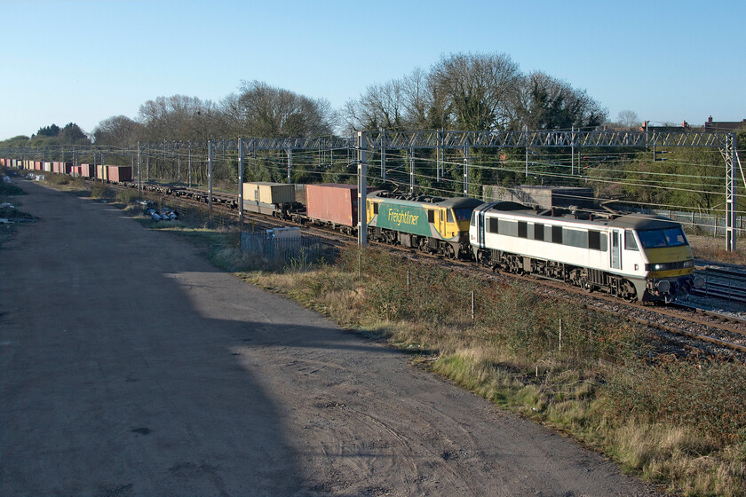 90003 & 90045, 02.57 Felixstowe North-Garston (4M45, 54E), site of Roade station 
 With it all over now for the Class 86s, 90s have now taken over their former Freightliner duties. The 90s make very easy weather of their work travelling noticeably quicker than Class 66s and surely more efficiently in the process. Passing the site of Roade station former Greater Anglia 90003 leads 90045 on the 02.57 Felixstowe to Trafford Park 4M45 service. 
 Keywords: 90003 90045, 02.57 Felixstowe North-Garston 4M45 site of Roade station Freightliner