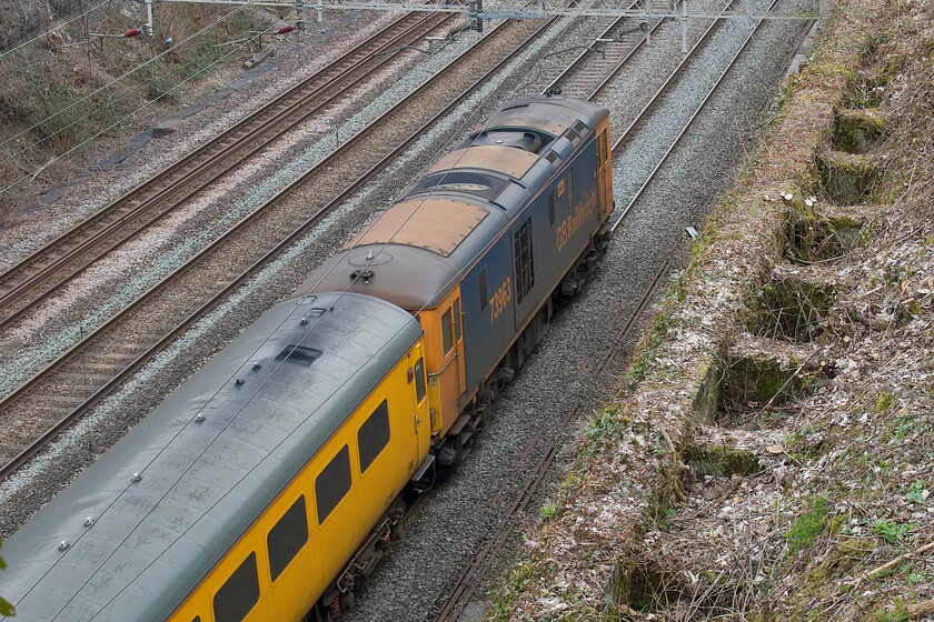 73963, 10.55 Hither Green-Derby RTC (1Z10, 55E), Roade cutting 
 The passage of Electro Diesels (Eds) through Roade cutting, or anywhere on the WCML for that matter, is fairly unusual. 73963 Janice is seen at the rear of the 1Z10 10.55 Hither Green to Derby RTC Network Rail test train that was returning to its base on the down fast line passing through Roade cutting. This is my first picture of this converted Class 73 that was formally numbered E6030, 73123 and 73206 
 Keywords: 73963 10.55 Hither Green-Derby RTC 1Z10 Roade cutting Janice Network Rail ED