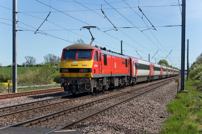 90036, GR 13.54 Newark Northagte-London King`s Cross (1B85, 1L), Hough Lane SK860485 
 Some five miles into its journey, with one hundred and fifteen to go (according to the milepost) 90036 'Driver Jack Mills' powers the rear of the 13.54 Newark Northgate to King's Cross. It is purely coincidental that this Class 90's DB livery is such a close match to the former Virgin East Coast paint scheme as applied to the superb Mk. IV stock. This location is down a green lane just south of the village of Claypole at a foot crossing known as Hough Lane. Notice the up Claypole loop to the left of the train. 
 Keywords: 90036 13.54 Newark Northagte-London King`s Cross 1B85 Hough Lane SK860485