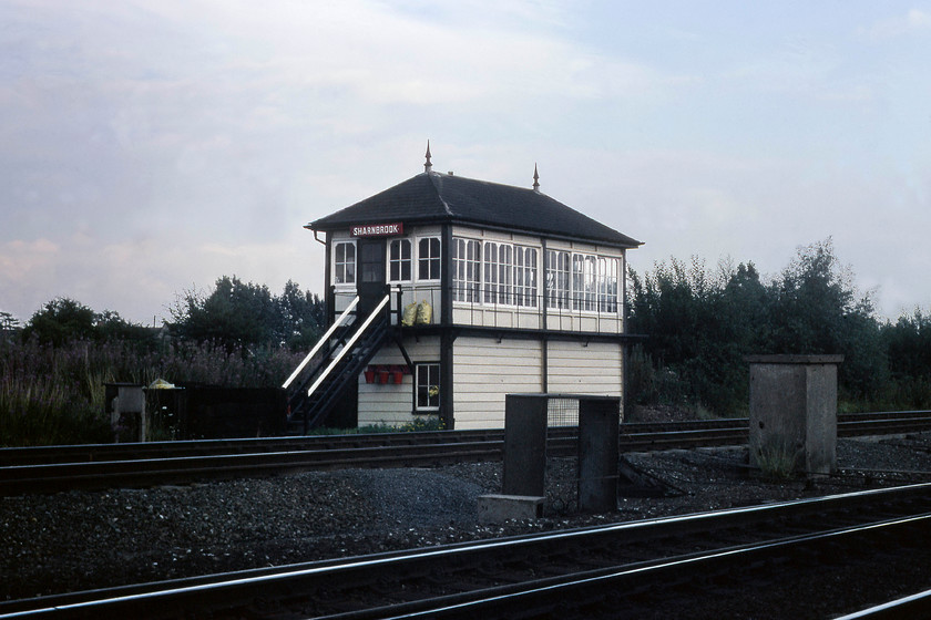 Sharnbrook signal box (Midland, date not known) 
 The typically Midland signal box at Sharnbrook is seen in the evening light. It is an example of the 2B type box, that was a very common design but, unfortunately, I have no details of when it was opened. I would suspect that it would date from c.1890. This picture is taken from the old goods yard, that itself was situated at the southern end of the former down fast platform of the station that closed on 02.05.60. The box closed when the MML MAS scheme was switched on in 1981 with control moving the West Hampstead PSB. 
 Keywords: Sharnbrook signal box