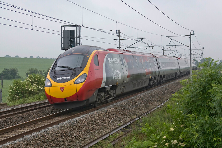 390155, VT 06.10 Manchester Piccadilly-London Euston (1M64), Milton crossing 
 The livery seen here applied to 390155 was revealed some three months ago on 31.03.14 at Euston station. It was unveiled as part of the promotion of the forthcoming film X Men: Days of Future Past by two of the film's stars, Hugh Jackman and James McAvoy. Not a film I have seen but to be fair, it's not really my sort of thing! The Pendolino is seen passing Milton crossing near Blisworth working the 06.10 Manchester to Euston service. 
 Keywords: 390155 06.10 Manchester Piccadilly-London Euston 1M64 Milton crossing Virgin West Coast Pendolino